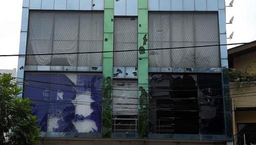 Broken windows are pictured at the Muslim-owned Fashion Bug store