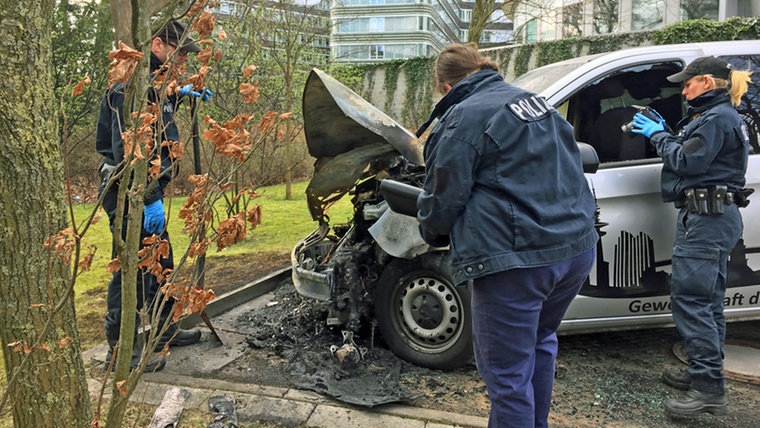 Der Staatsschutz übernimmt wegen der Brände die Ermittlungen. Am Freitagmittag sichern Polizisten die Spuren an dem verbrannten Auto der Gewerkschaft. 