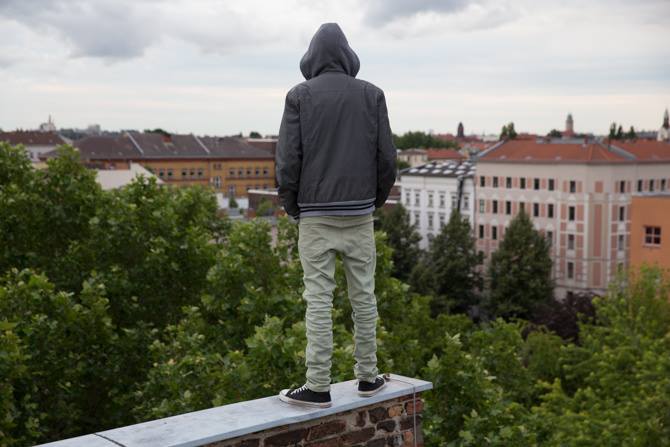 Mensch steht auf Mauer