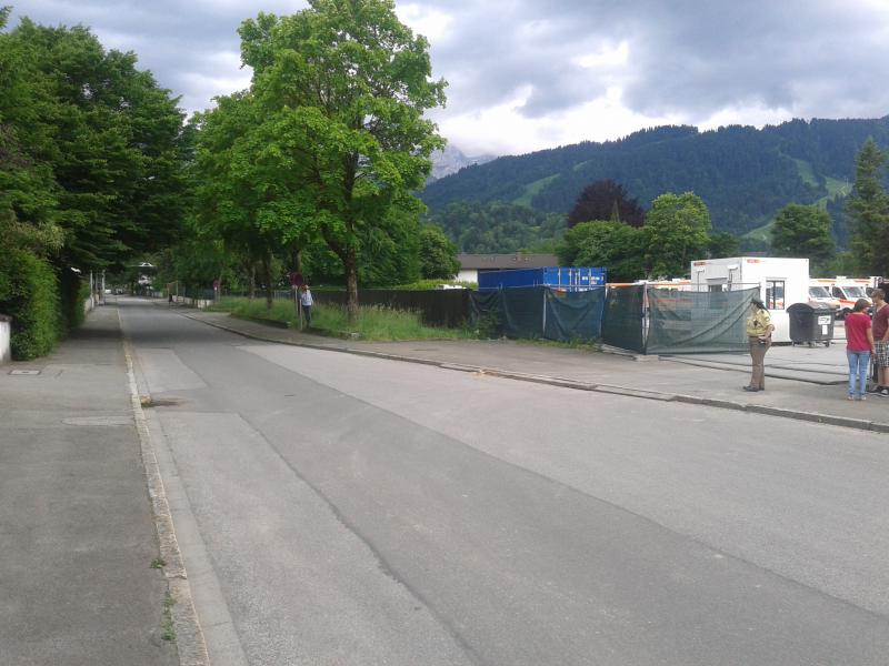 Einfahrt auf den Parkplatz (mit Bürgerspitzeln und Mordmaschine für das Kapital)