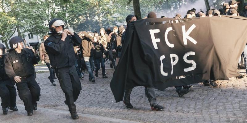 demonstranten mit fck cops plakat