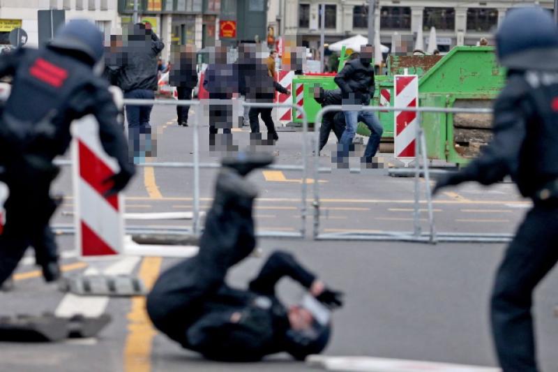 Ein Polizist stürzt zu Boden.  / Verpixlung: Indymedia