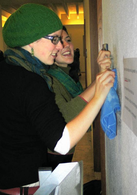 Zwei Studentinnen entfernen Graffiti in der Uni Basel.